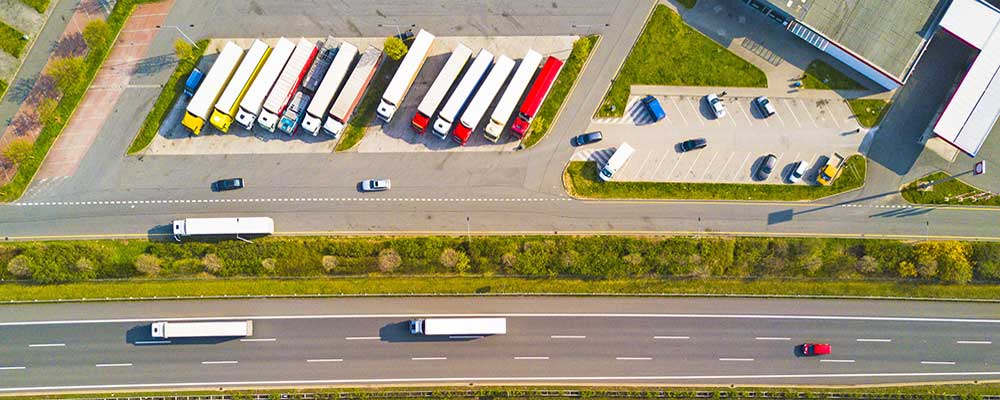 Aerial photo of semi trucks at a rest stop next to a highway